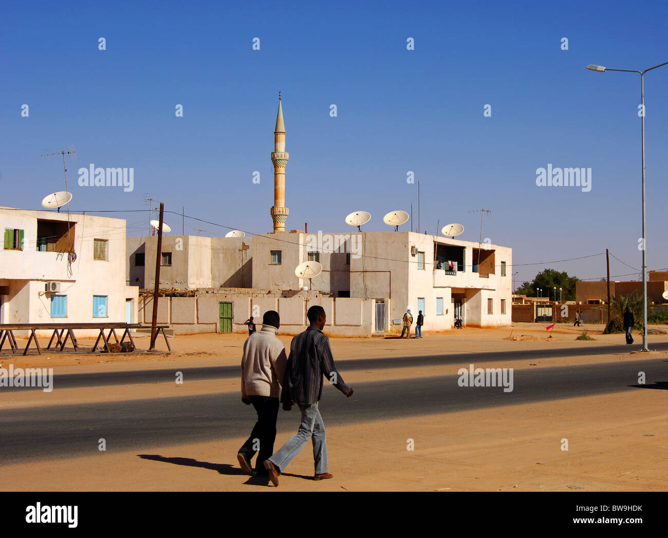 Residential houses with satellite dishes on the roof and the minaret of a mosque in the town of Jerma, Libya Stock Photo