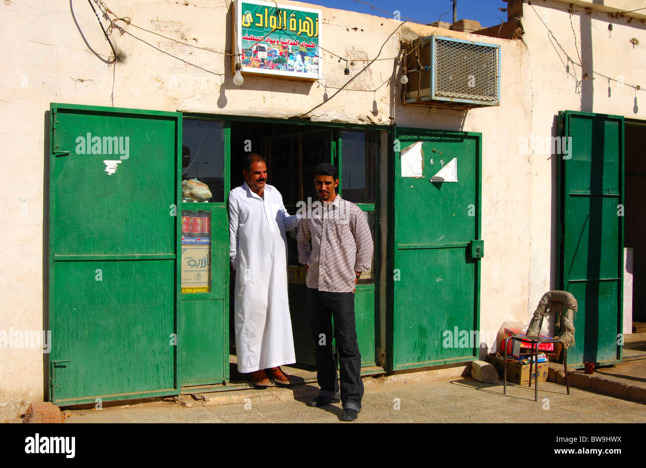 Two Arab men standing at the entrance to a Mom-and-Pop grocery store, Jeerma, Libya Stock Photo
