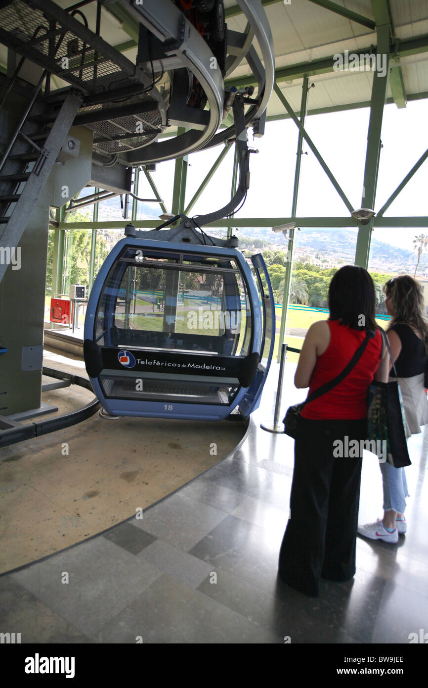 passengers waiting to board cable car as it moves round station.Funchal