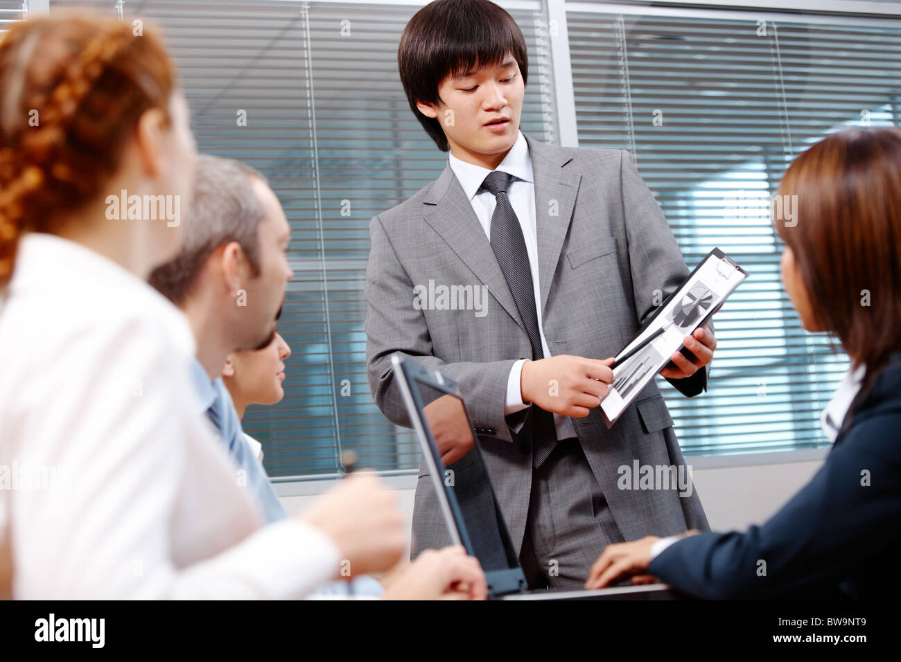 Photo of confident leader pointing at paper with diagrams during ...