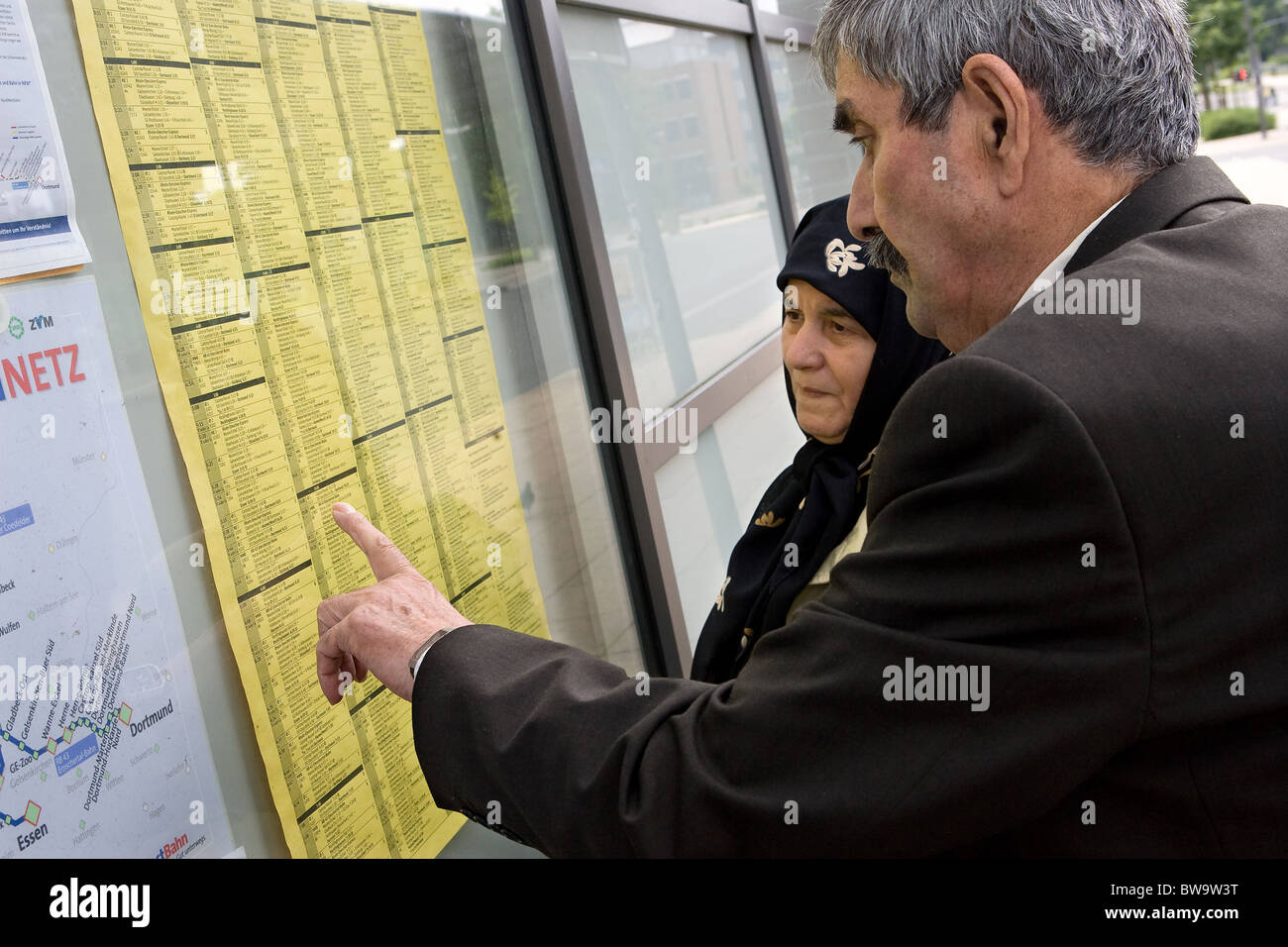 An elderly Turkish couple looking at a timetable, Herne, Germany Stock Photo