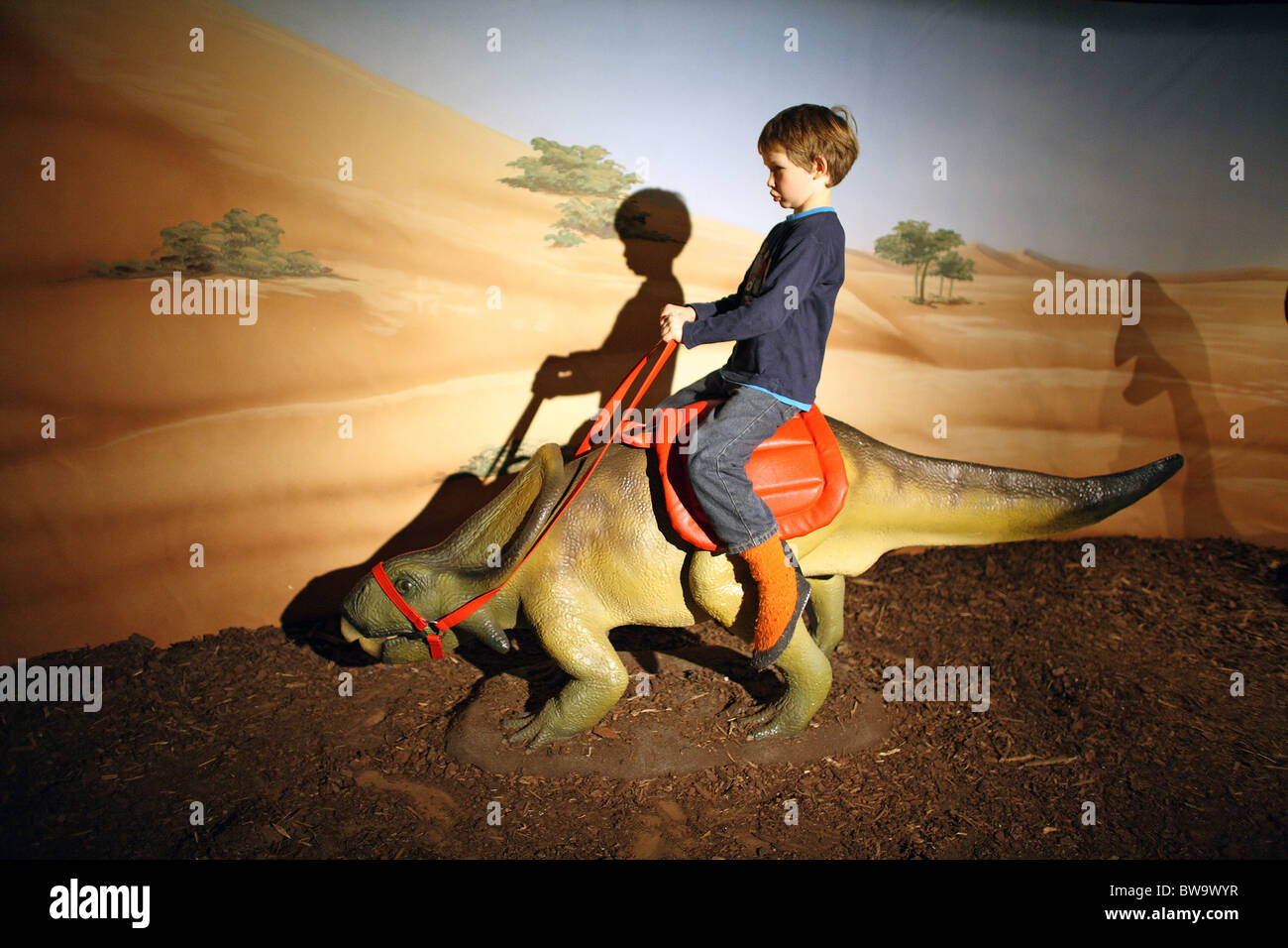 A kid riding on a dinosaur in the Alexa Kindercity, Berlin, Germany Stock  Photo - Alamy