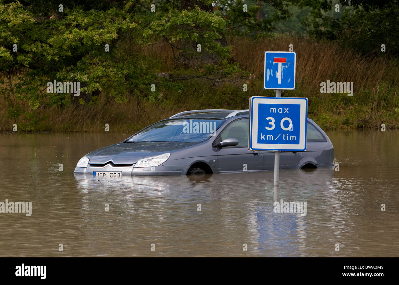 Car stuck on a flooded road Stock Photo