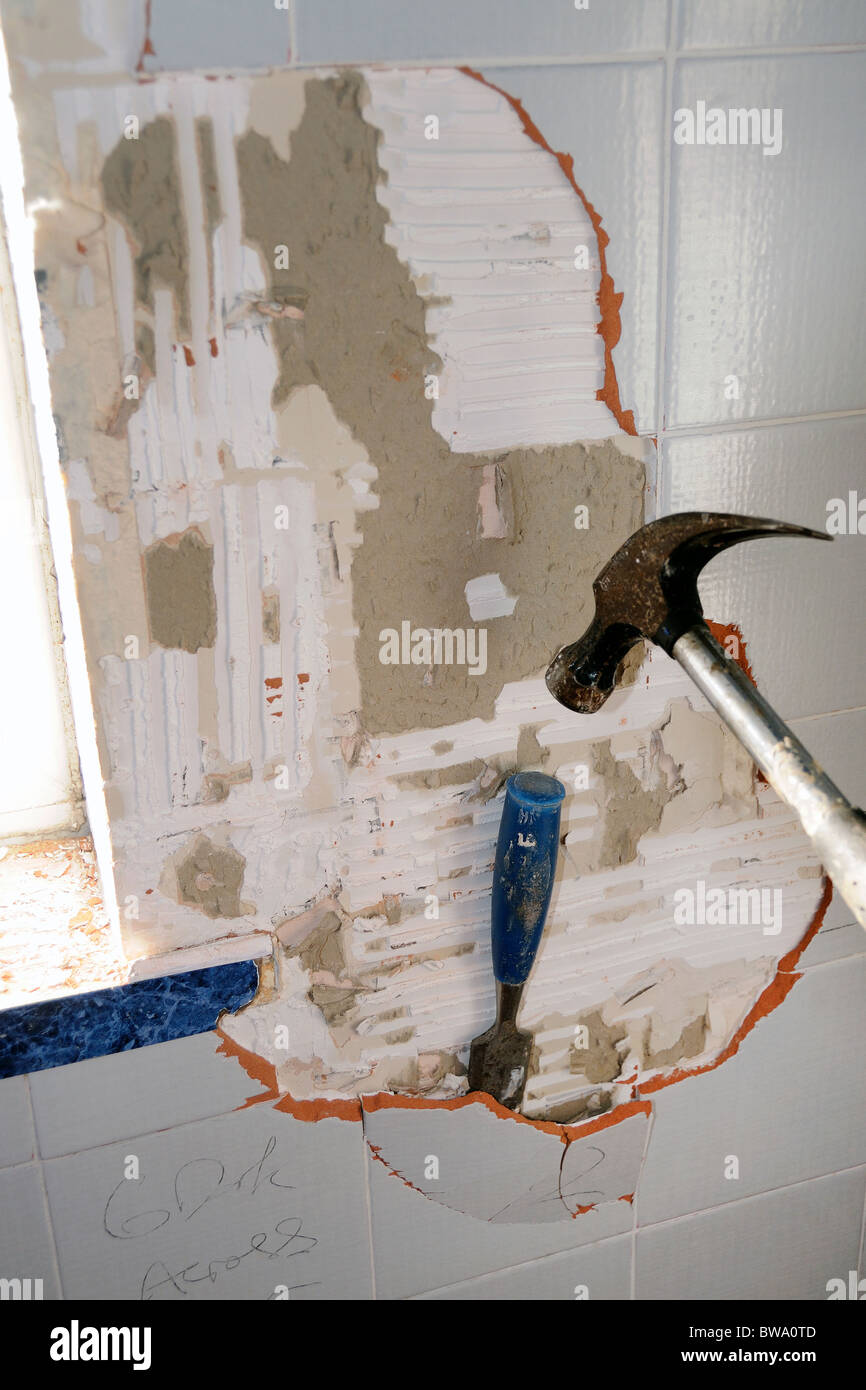 knocking old tiles off wall Stock Photo