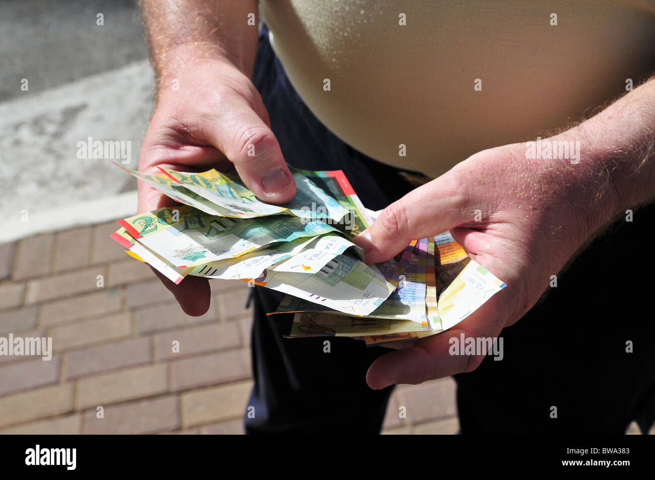 Man counting New Israeli Shekel banknotes Stock Photo - Alamy