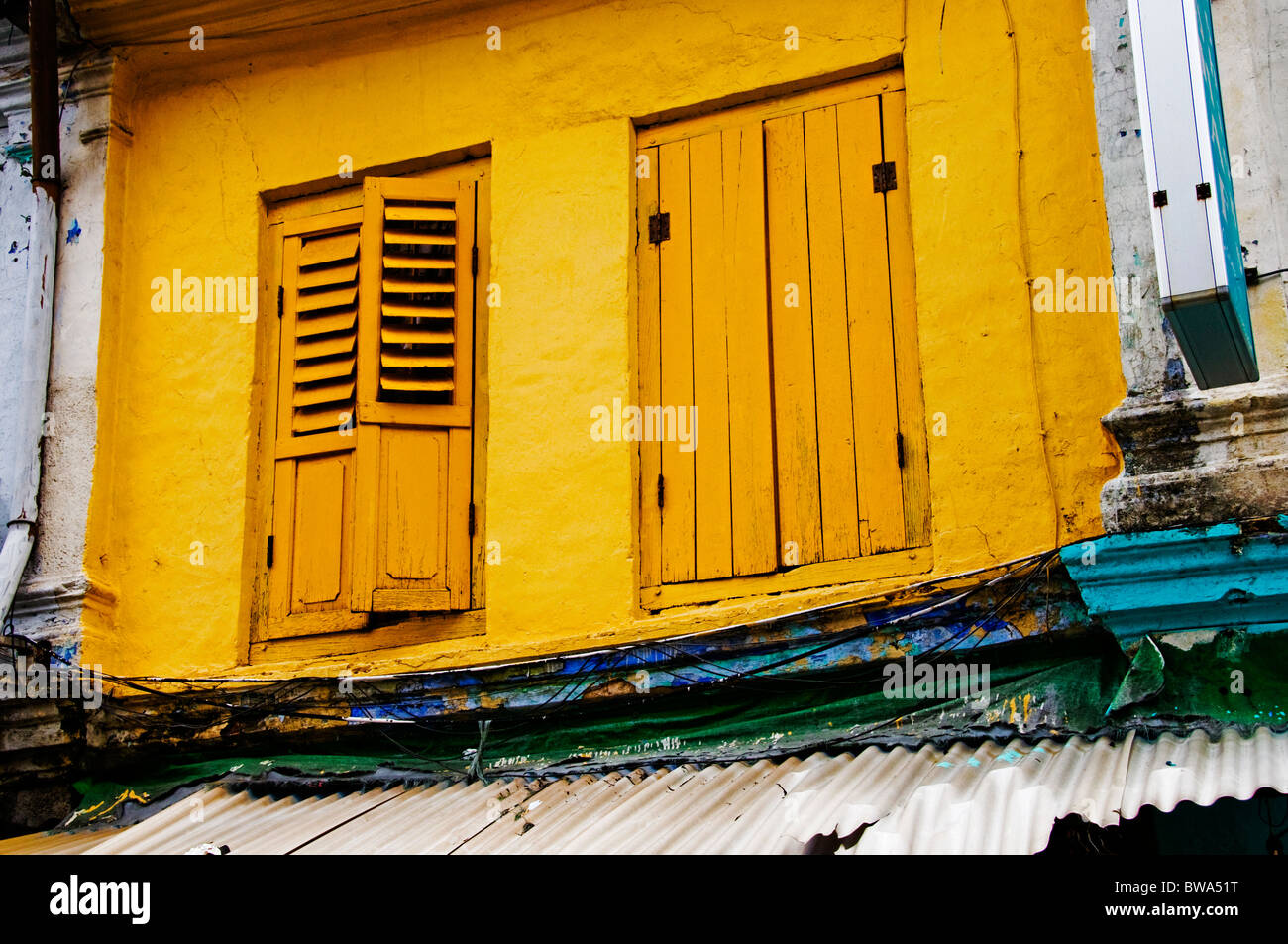 windows with shutters on second story apartment in Singapore Stock Photo