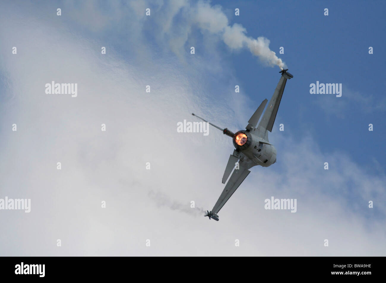 F-16 fighter jet plane flying and turning with afterburner on. Modern military aviation. Photo framed with copy space. Stock Photo