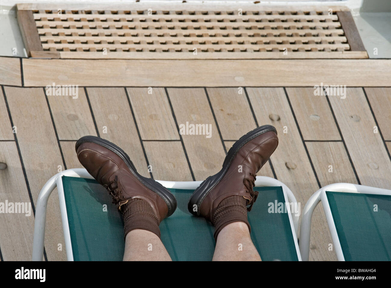 Passengers feet sunning on the deck of the Queen Mary II cruise ship. Style errors. Stock Photo