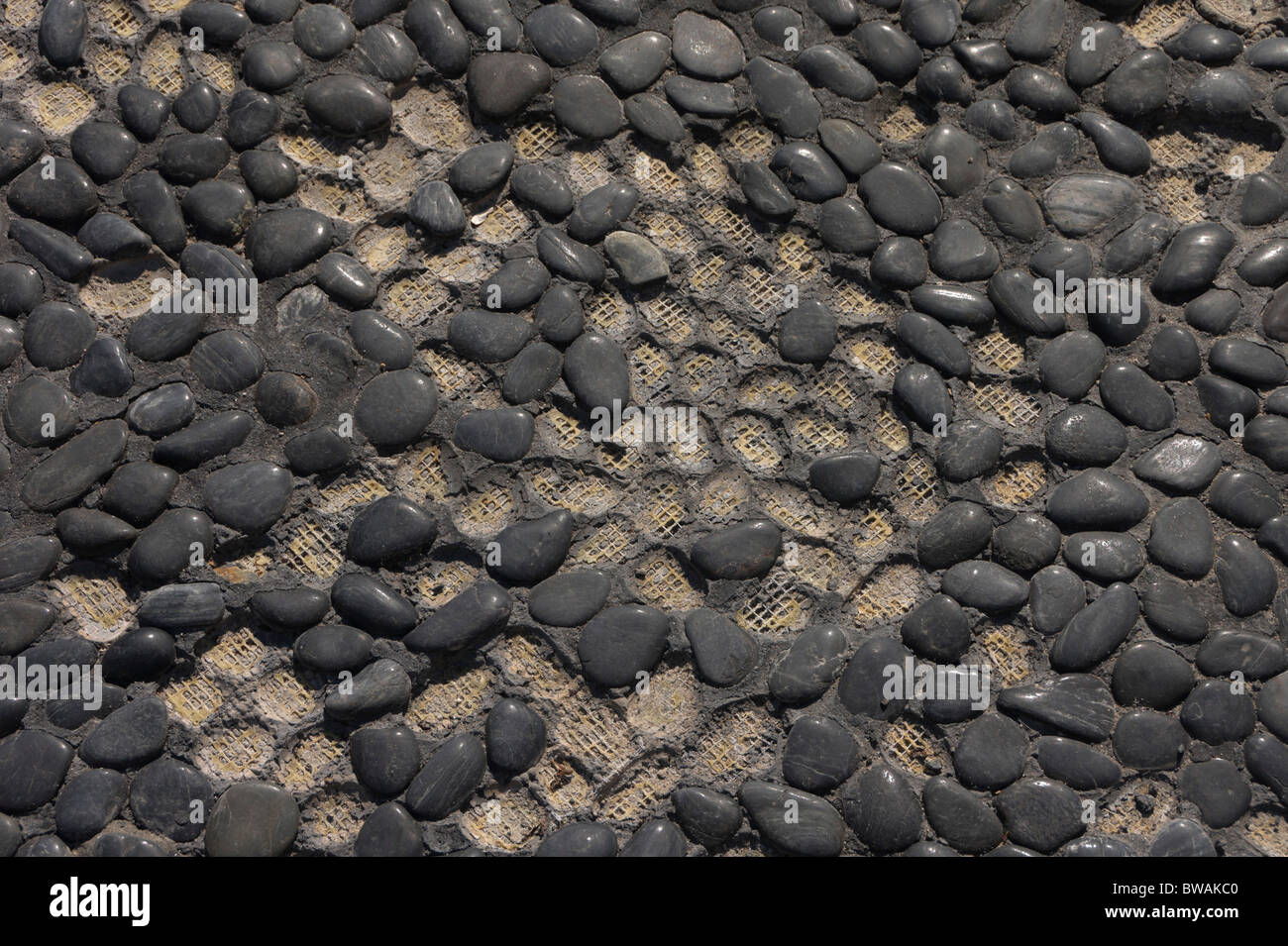 Fuerteventura, Canary Islands - cobblestones worn away off net used to tile outdoor area with area of stones. Stock Photo