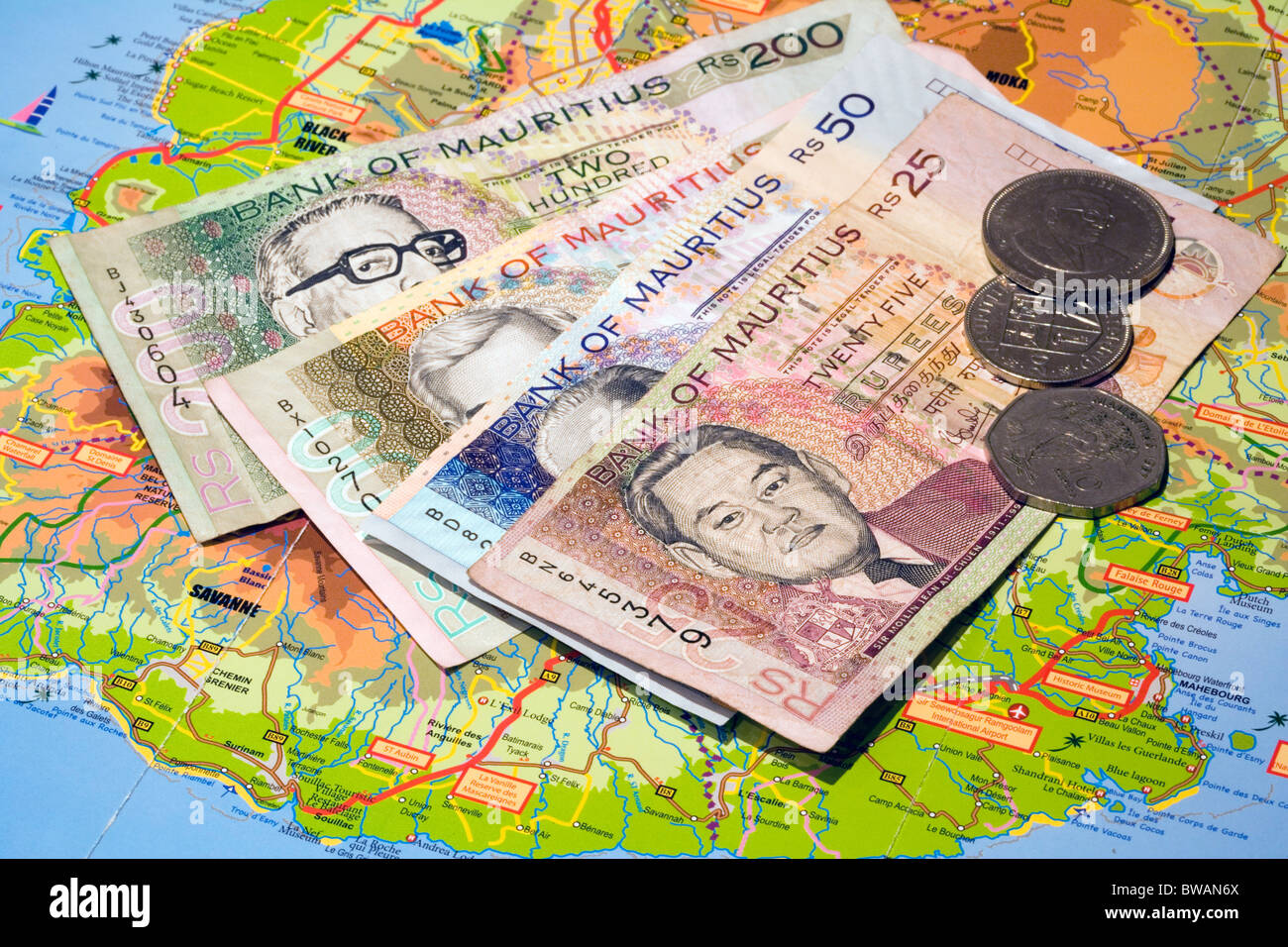 Mauritian Currency Bank notes and coins on map of Mauritius Stock Photo