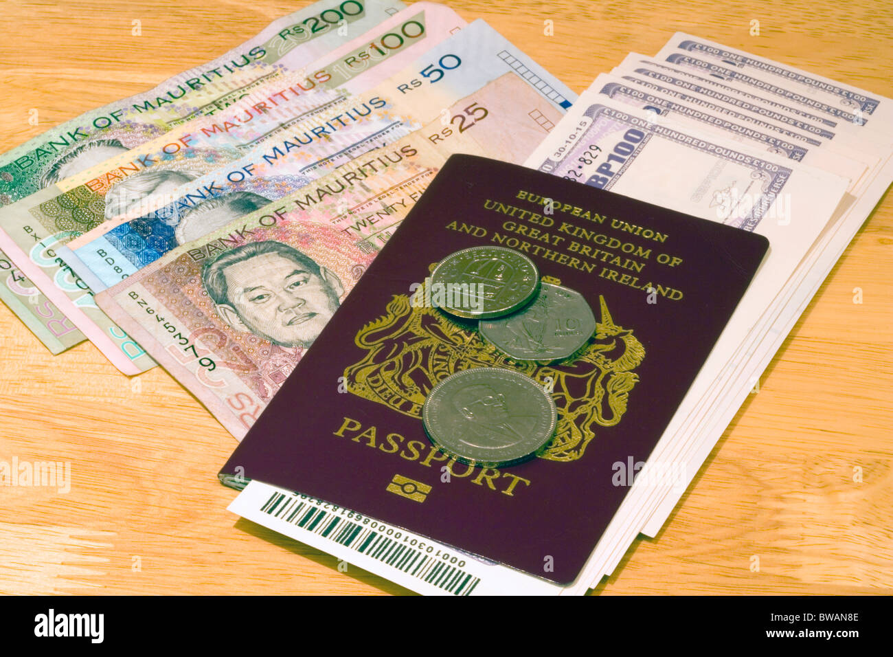 Holiday money. Mauritian Currency Bank notes, coins, Passport and Travellers Cheques - Mauritius Stock Photo