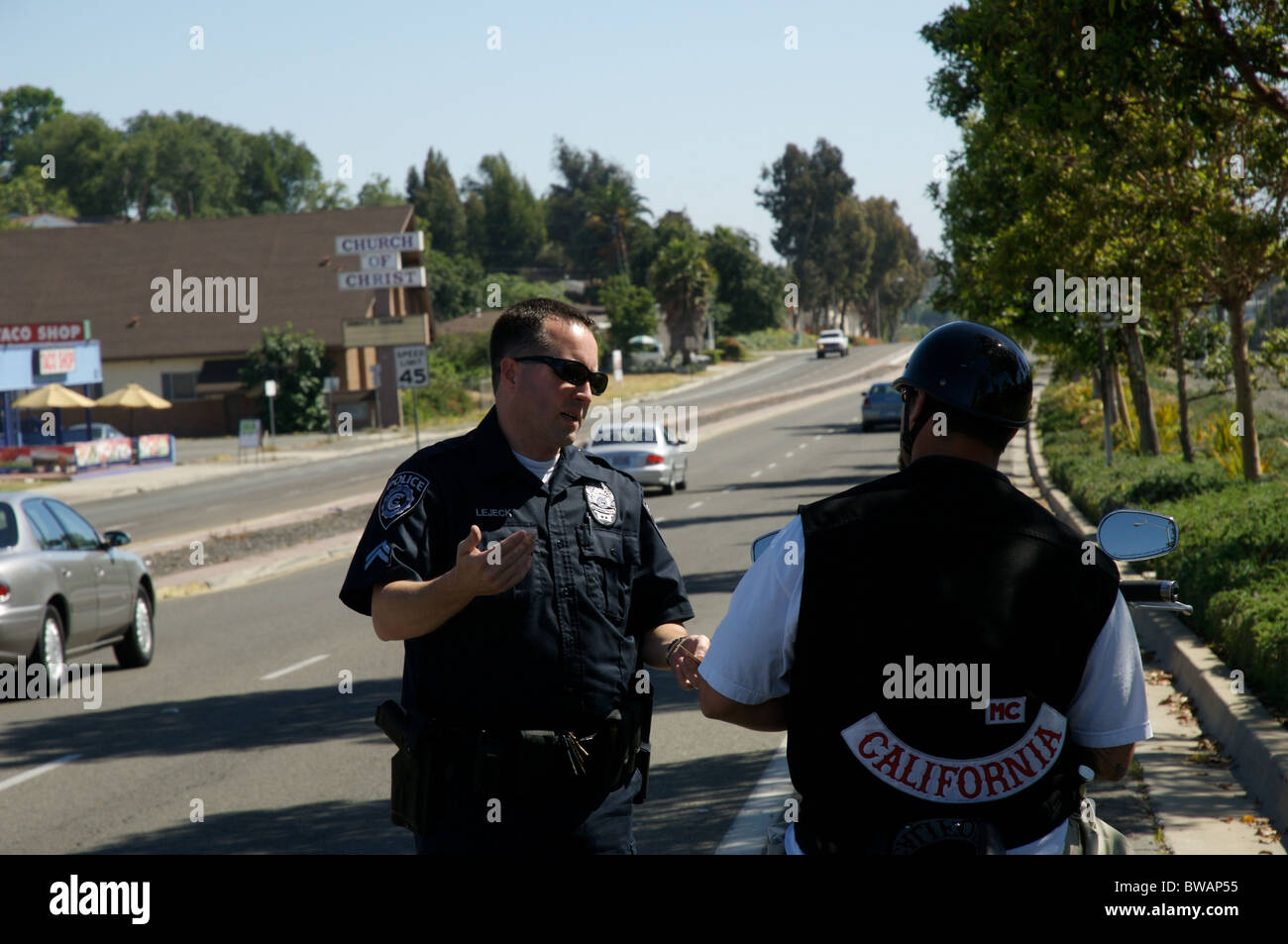 A police officer speaks with a Hell's Angel prospect after a traffic stop. Stock Photo