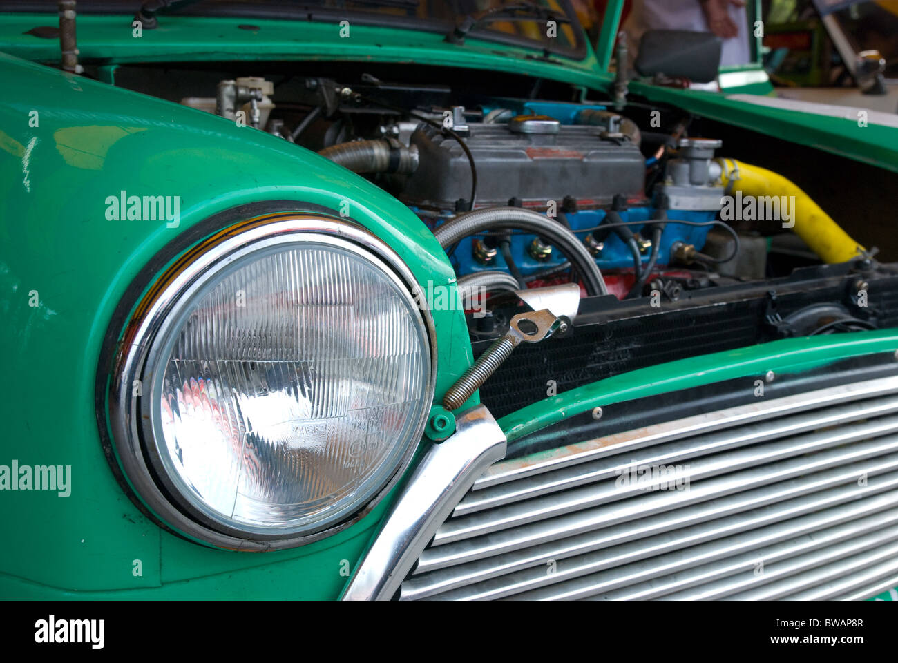 Front detail and engine of classic compact car from the sixties. Stock Photo