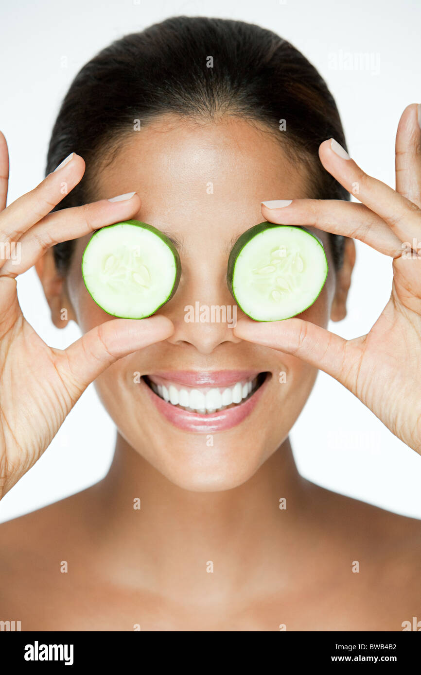 Woman holding cucumber over eyes Stock Photo Alamy