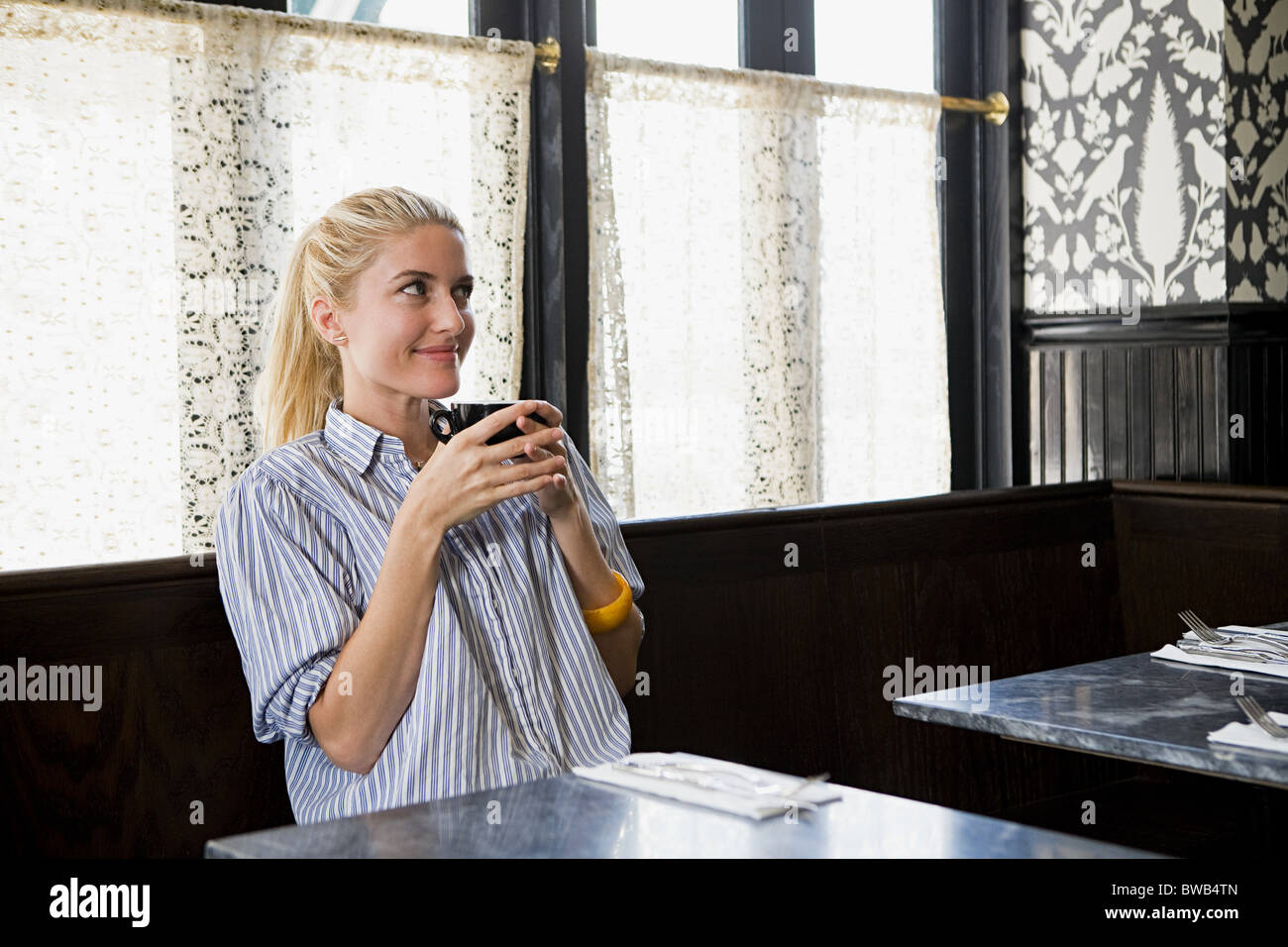 Woman having a drink at coffee shop Stock Photo