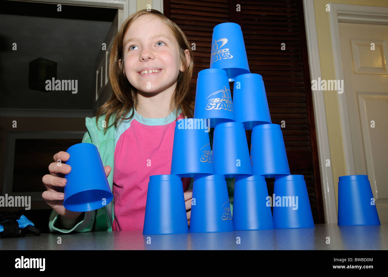 Young girl playing Speed Stacks using blue stacking cups Stock Photo