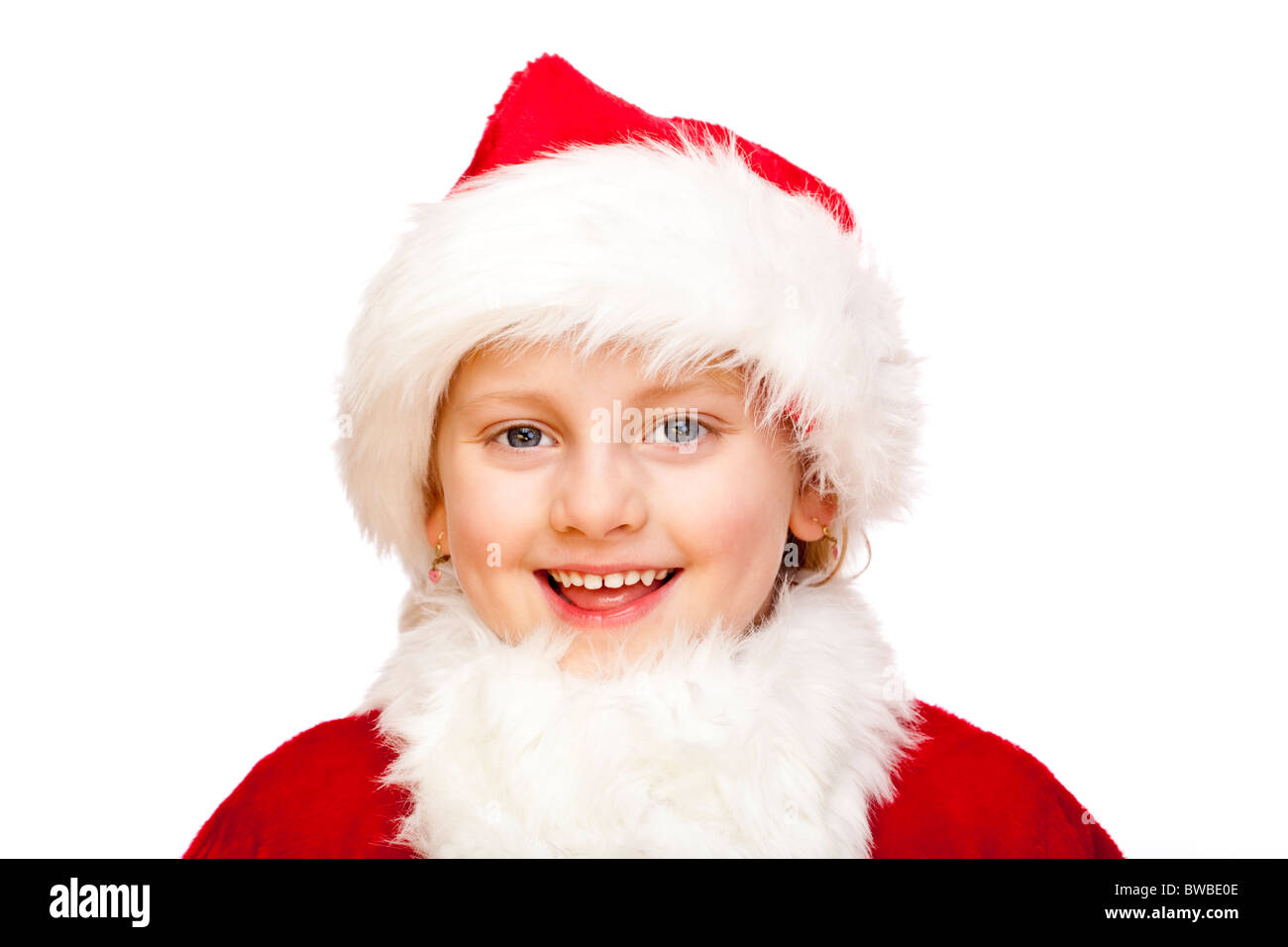 Small girl dressed as Santa Claus smiles happy into camera. Isolated on white background. Stock Photo