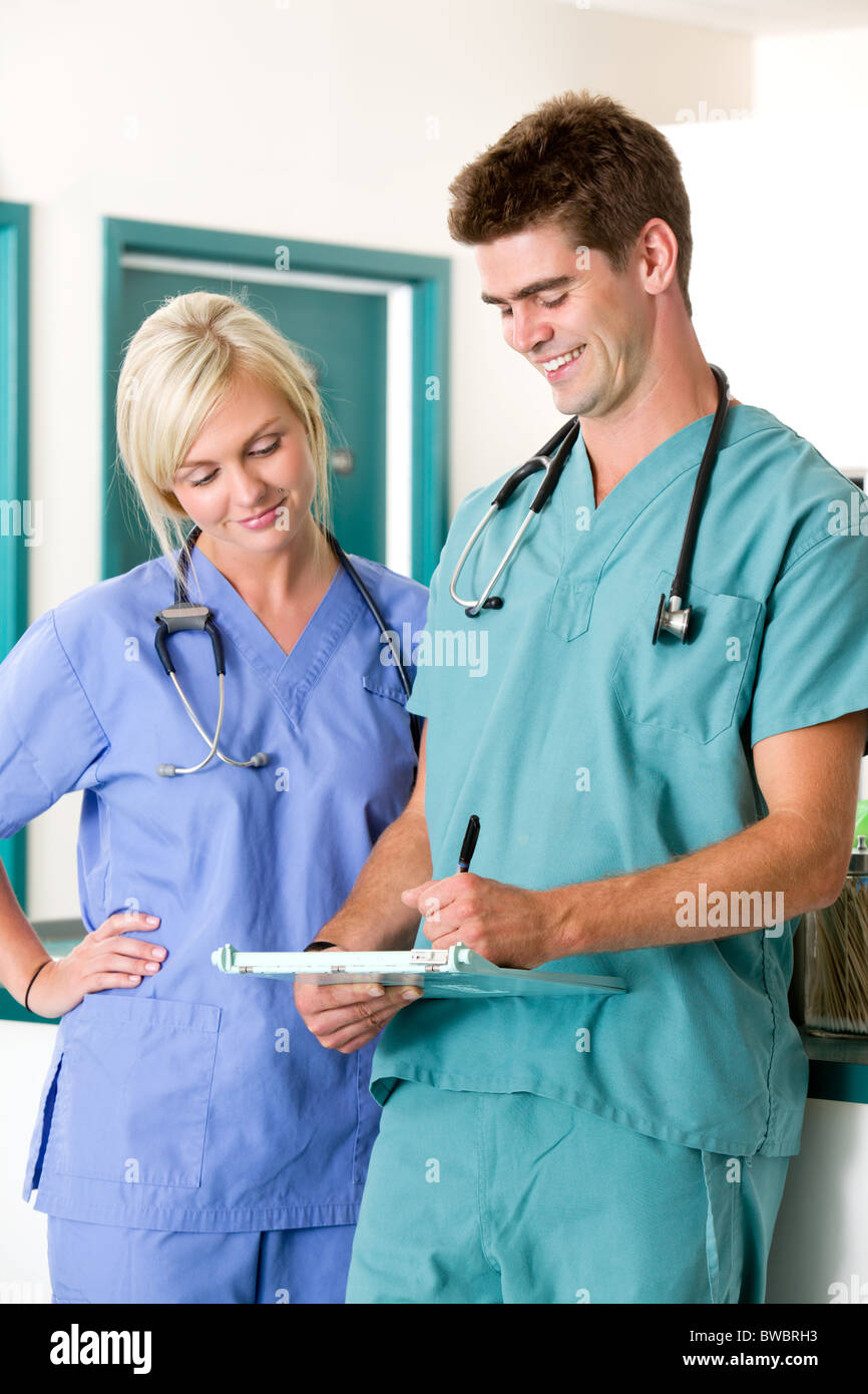 A vet and assistant looking and writing in a chart Stock Photo