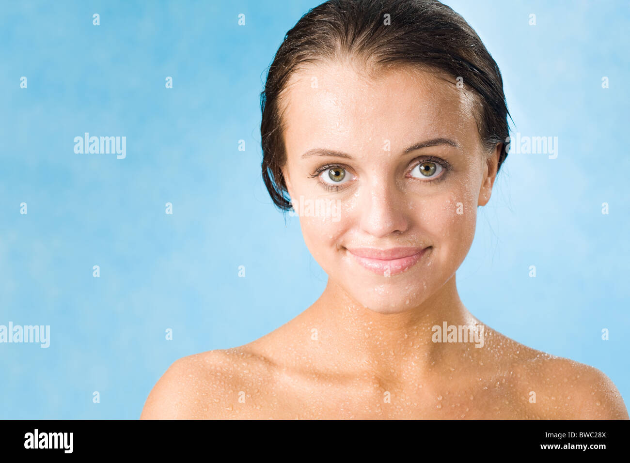 Portrait of pretty girl covered by waterdrops looking at camera over ...