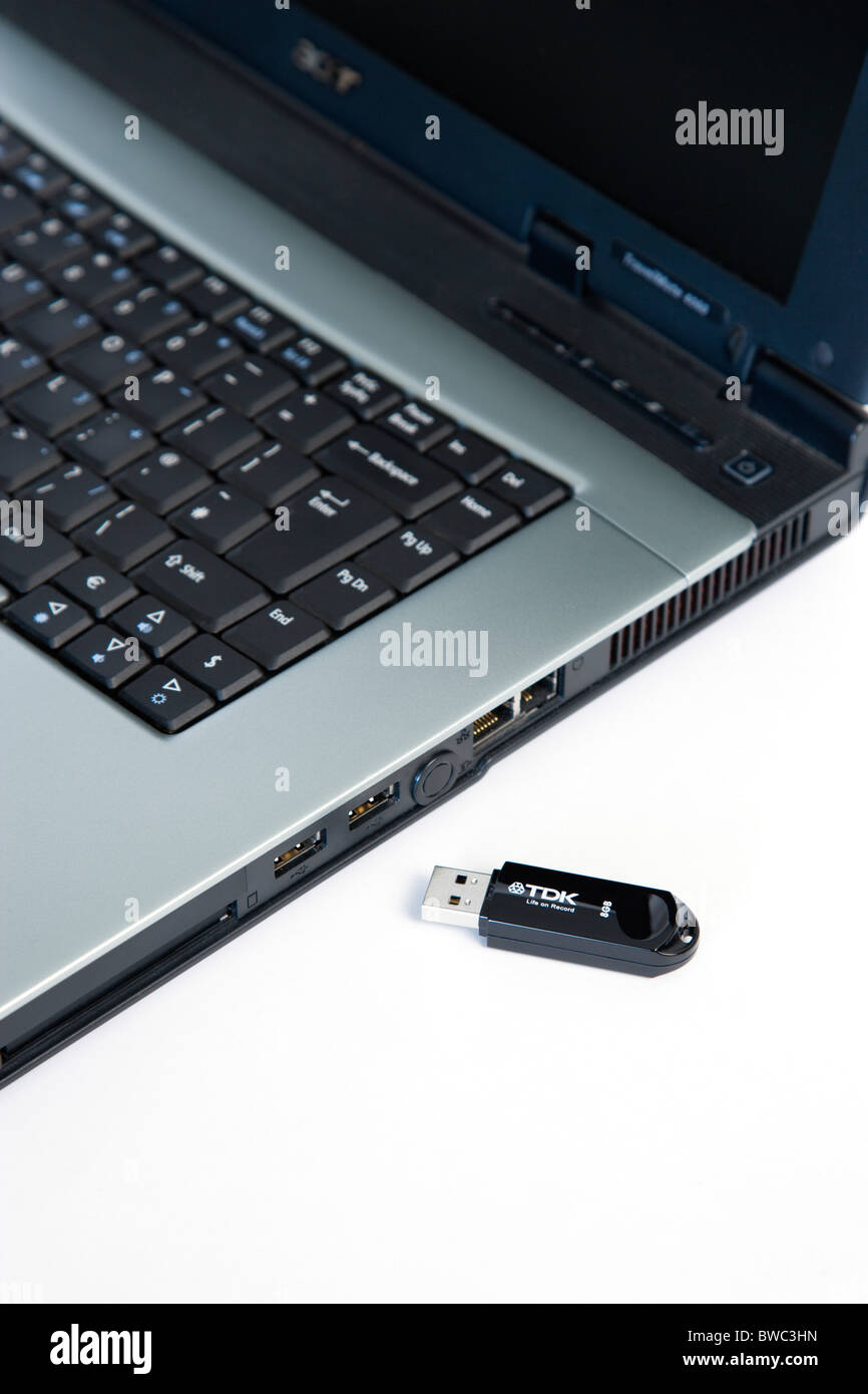 Industry, Computers, Components, 8 gigabyte portable USB flash stick drive memory storage device beside laptop computer USB port Stock Photo