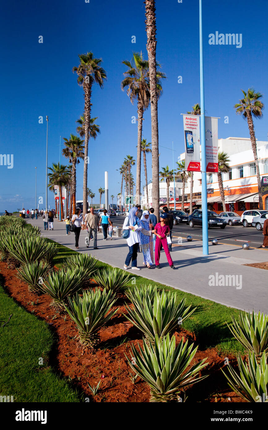 Moroccan pedestrians walk along the Corniche promenade in Casablanca, Morocco. Stock Photo