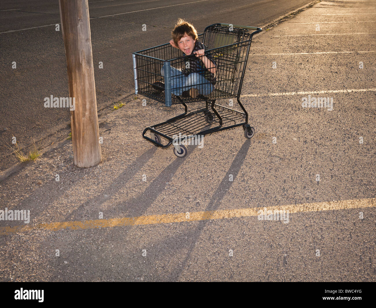Boy using shopping cart as a vehicle Stock Photo Alamy