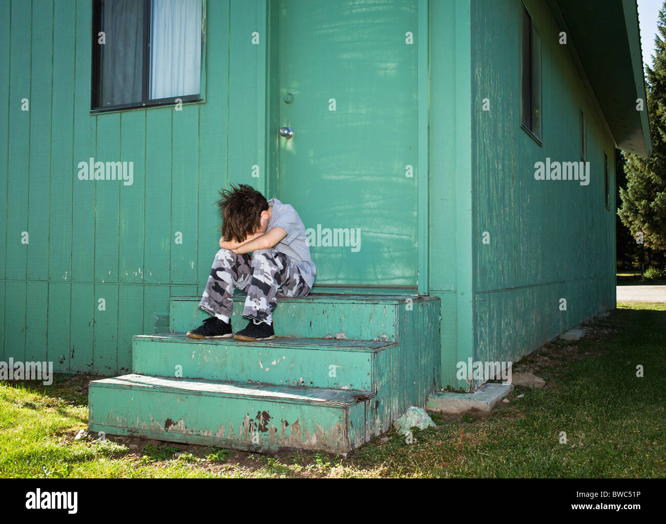 Boy Sulking on steps Stock Photo