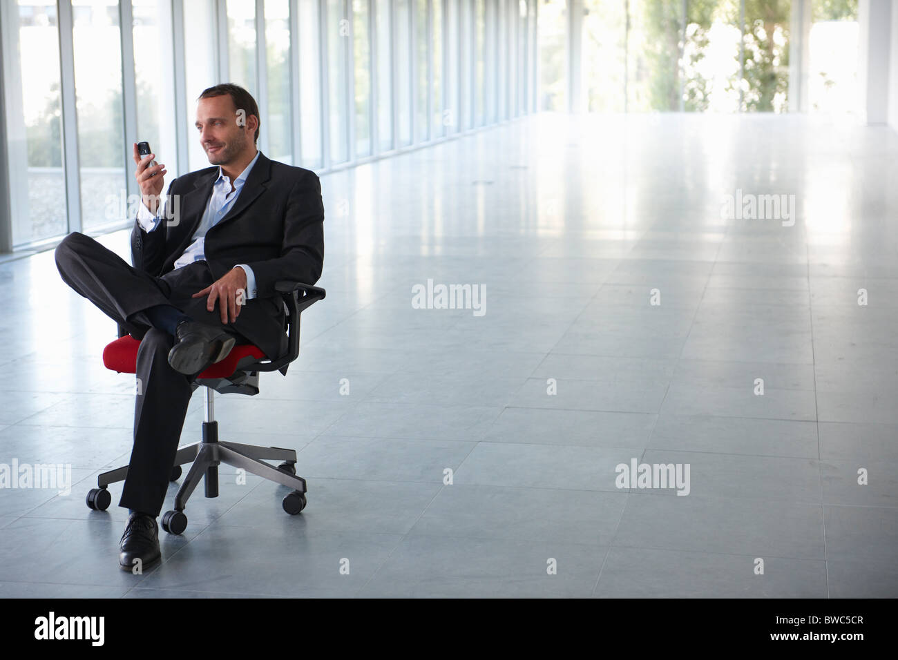 Businessman on a chair, in empty office Stock Photo