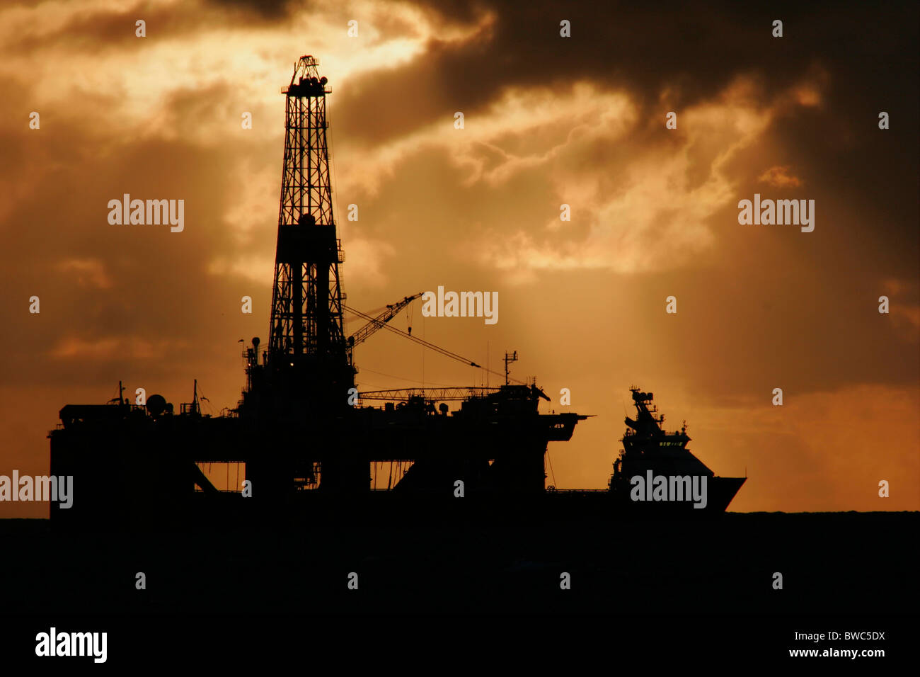 Silhouette of a supply vessel and oil rig in the North Sea, September 2006 Stock Photo