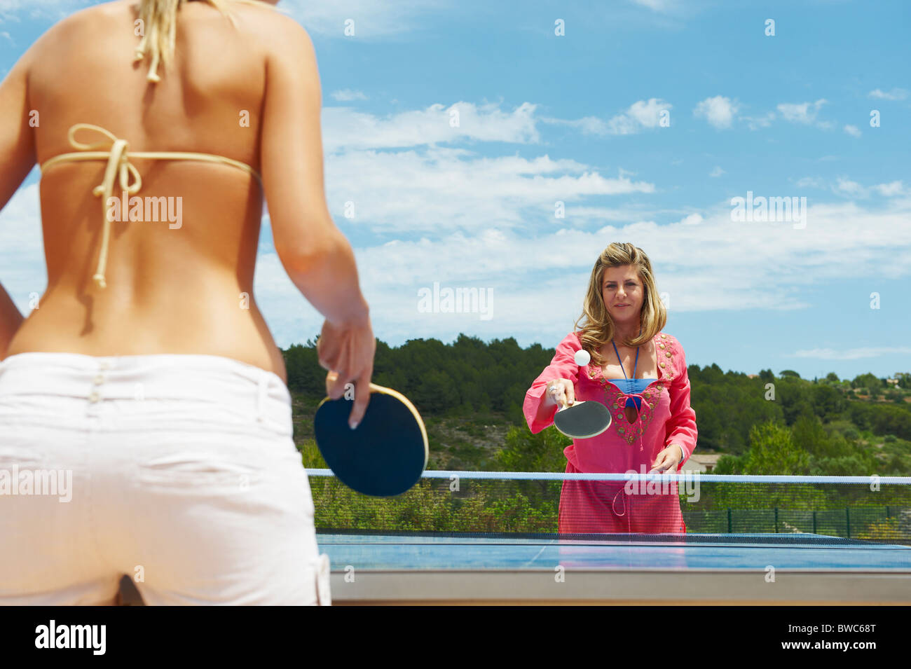 Two women playing table tennis outdoors Stock Photo