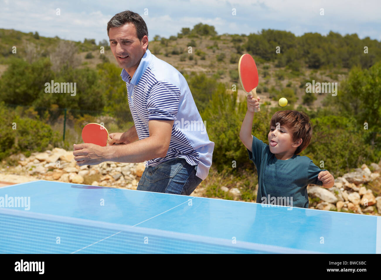 Father and son playing table tennis Stock Photo