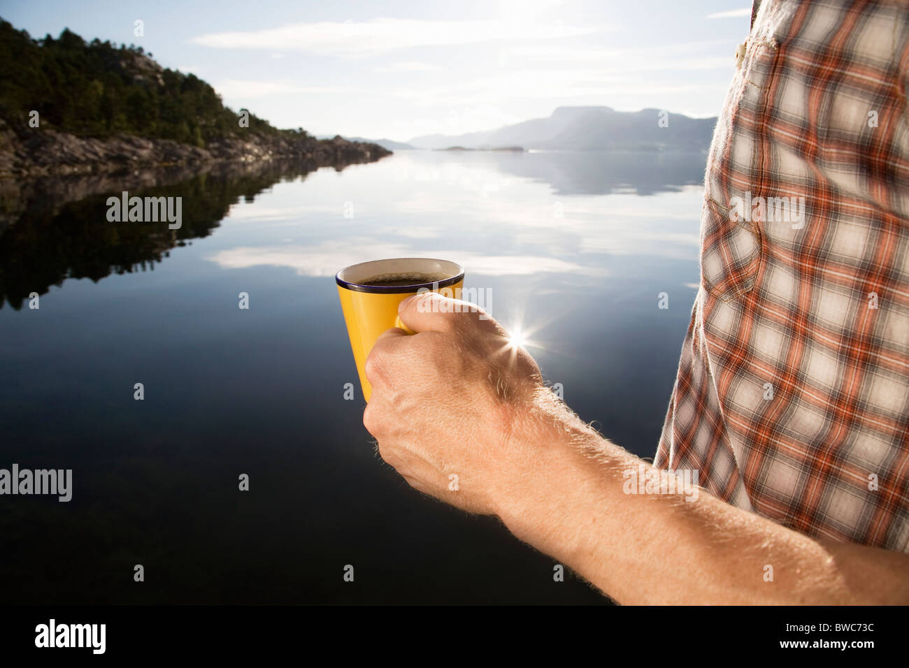 Man having coffee by sea and mountains Stock Photo