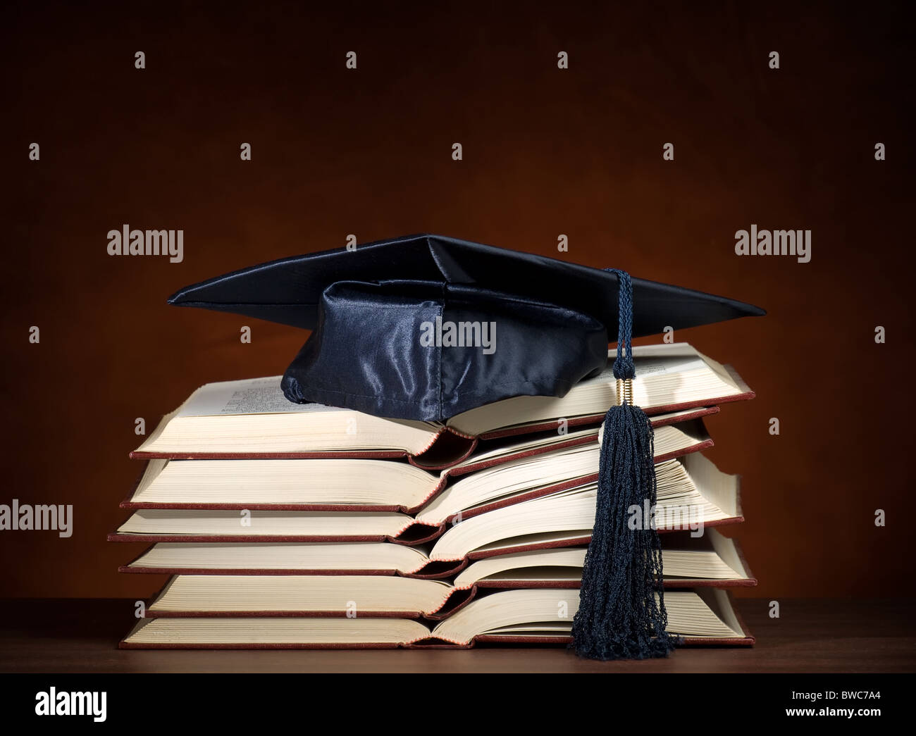 Stack of opened books and graduation cap, for various education ...