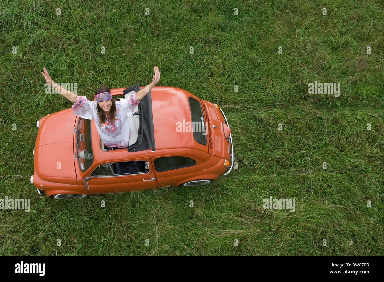 Hippy female stretching out of car Stock Photo