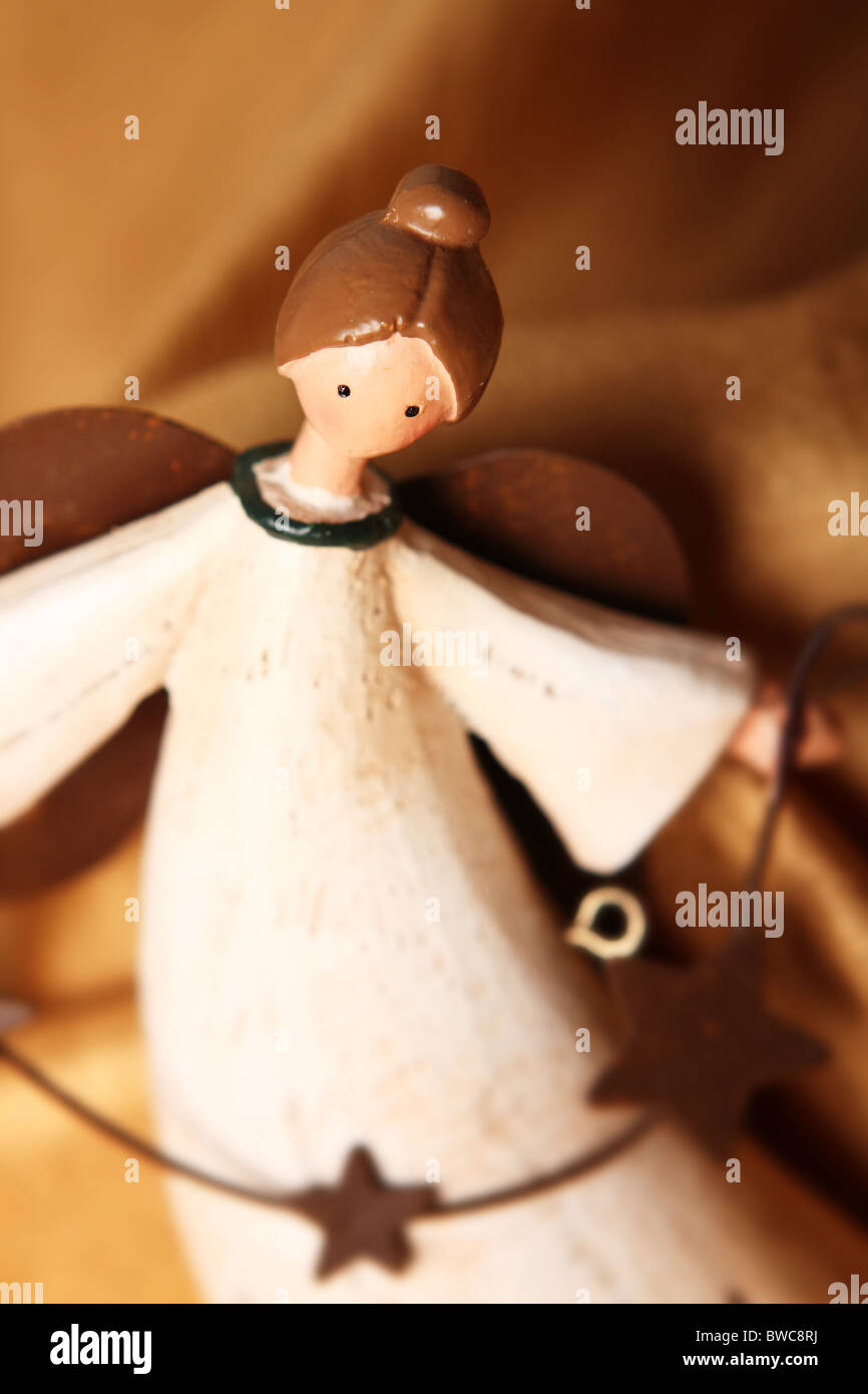 white antique Christmas angel ornament on a gold fabric background
