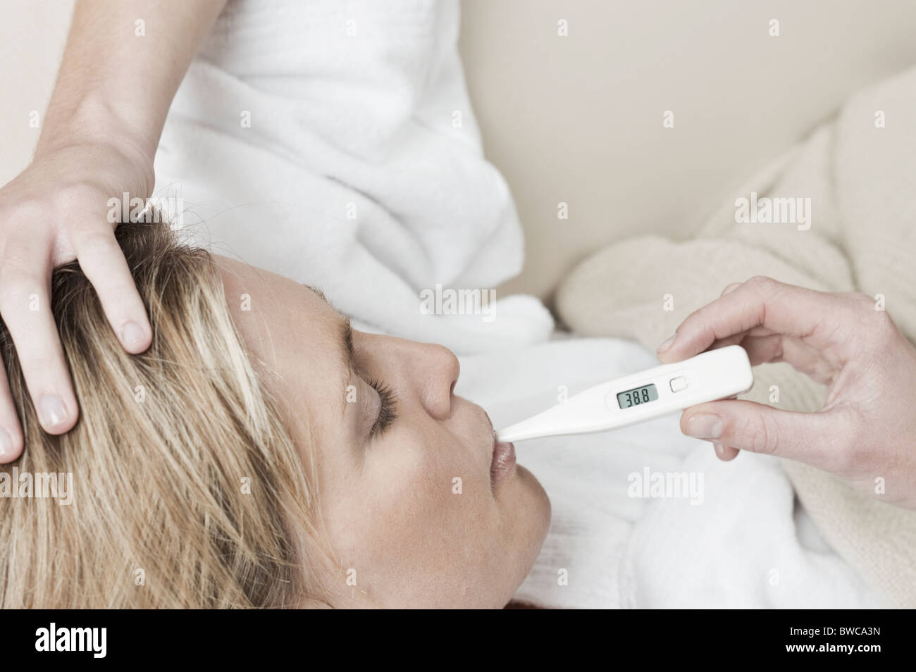 South Africa, Cape Town, Profile of sick young woman with thermometer in mouth Stock Photo