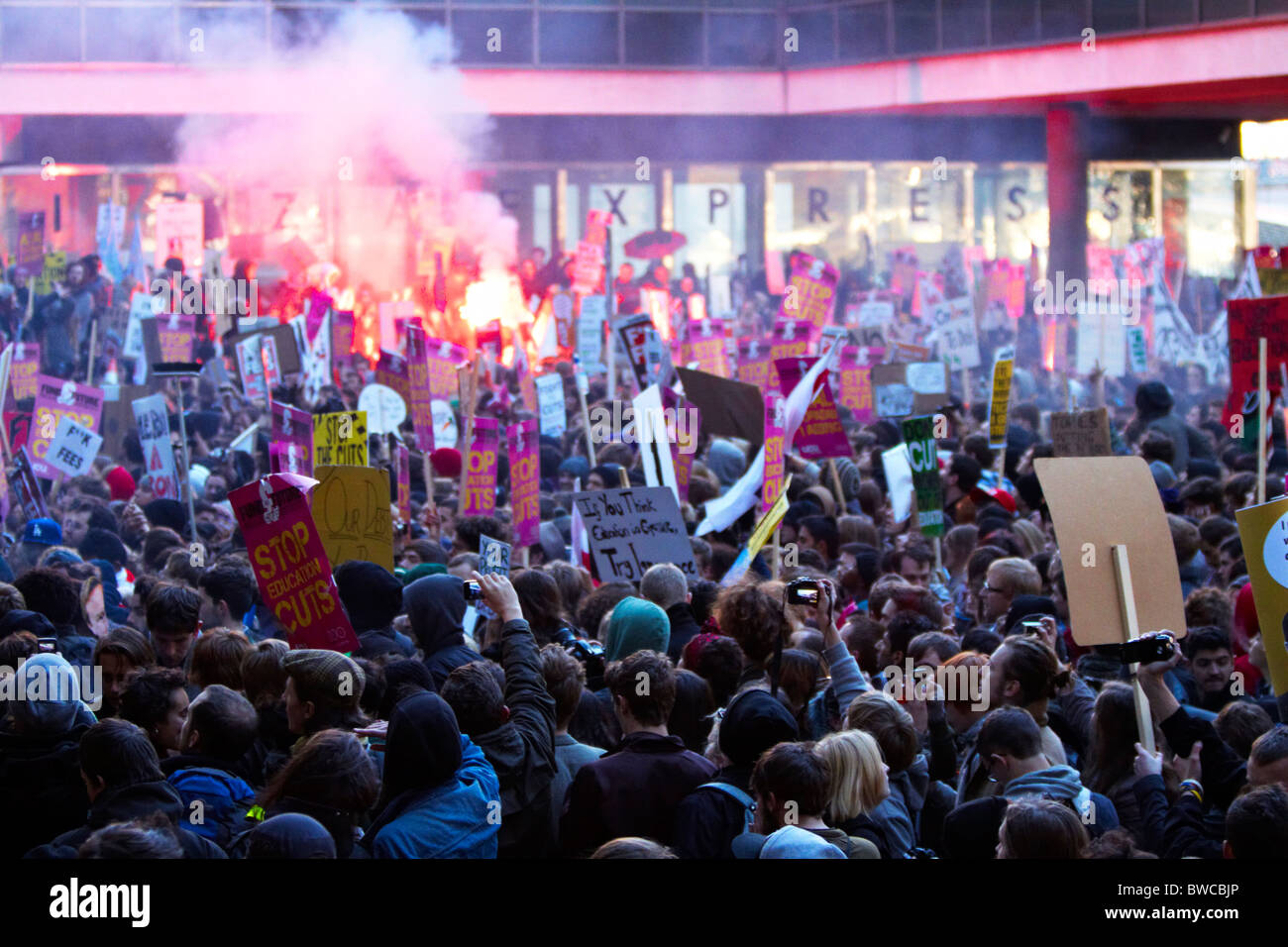 Protester lets off a flare during student protests against tuition fees ...