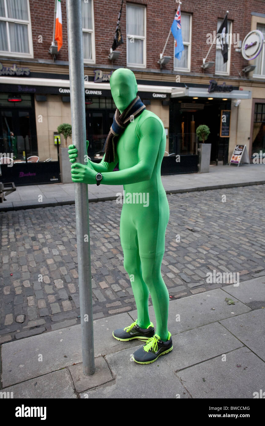 Man in green latex body hugging suit with scarf holding post in Temple Bar street of Dublin. Photo:Jeff Gilbert Stock Photo