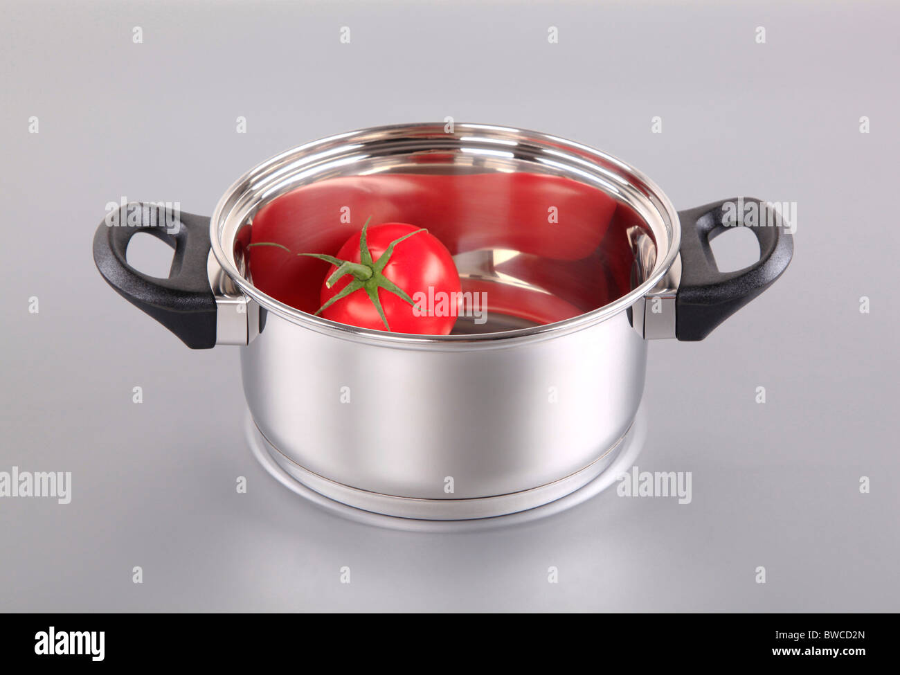 Red tomato in a shiny stainless steel pot Stock Photo Alamy
