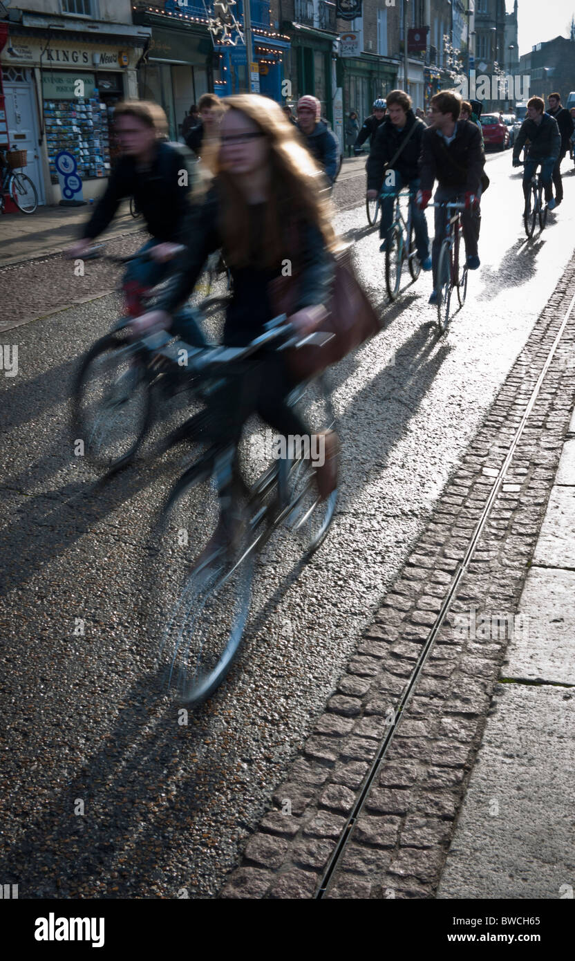 Students cycling to lectures in Cambridge in strong early winter sun Stock Photo