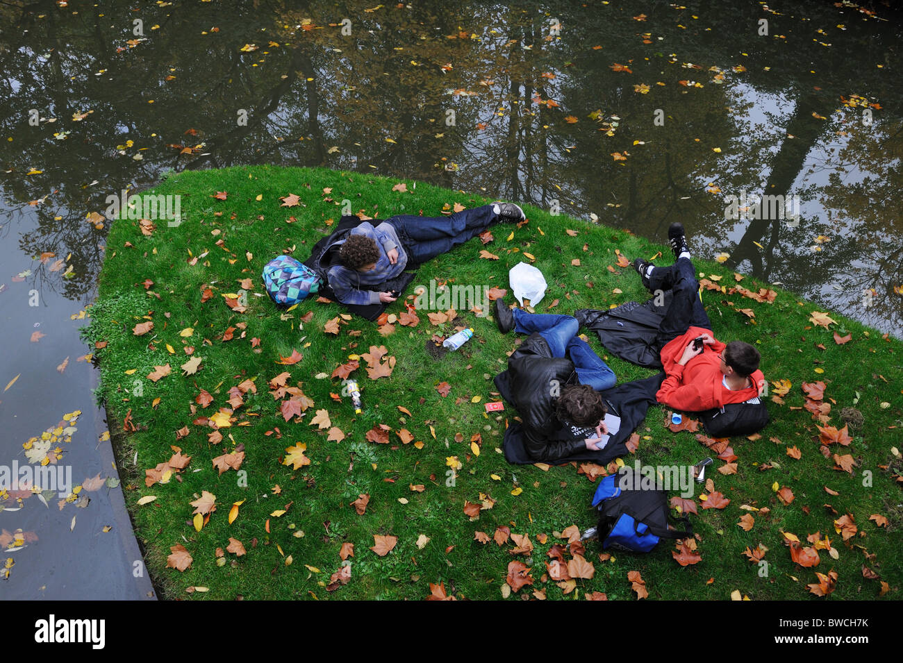 Students resting riverside, leisure time Stock Photo