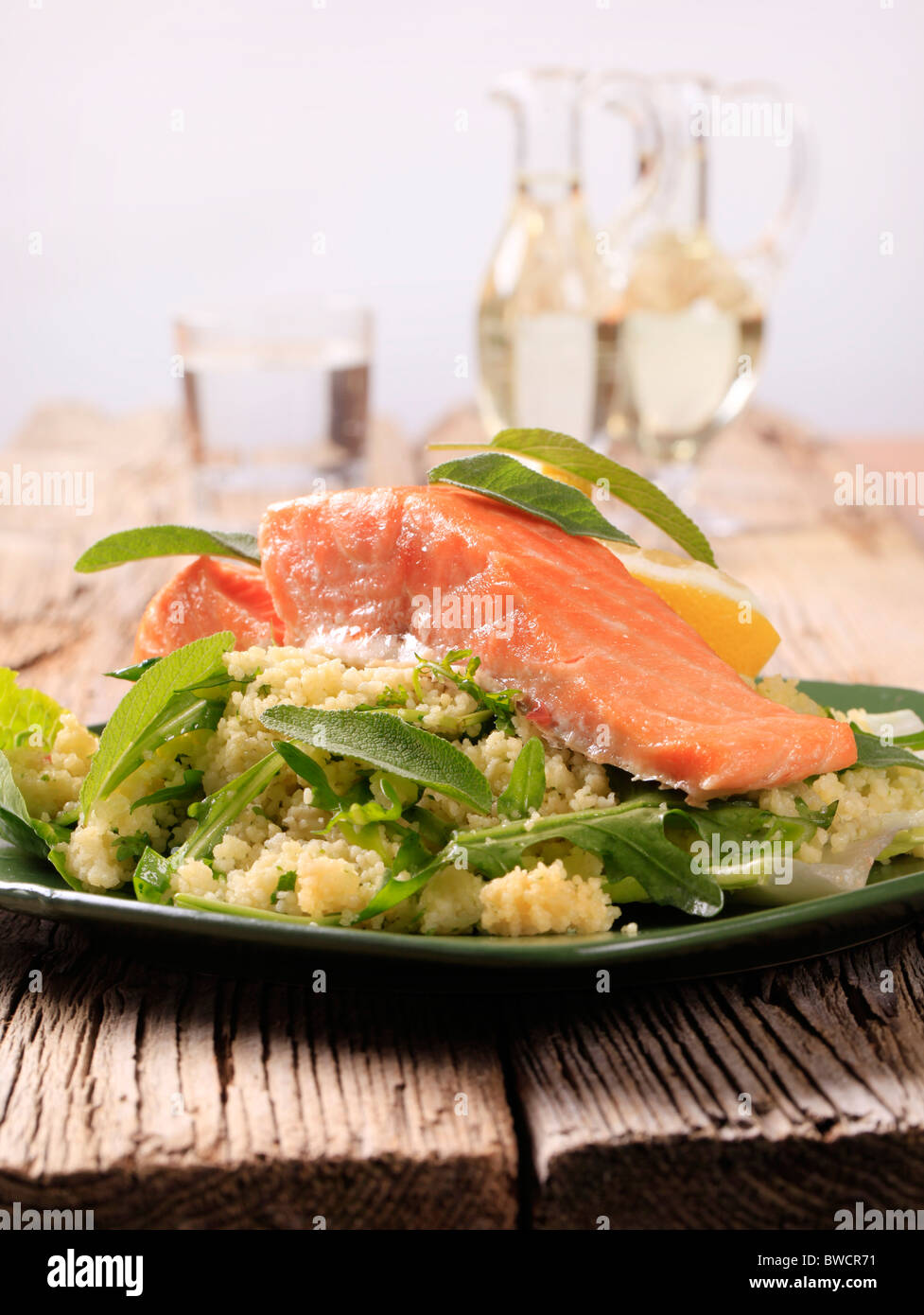 Salmon fillet and couscous garnished with fresh sage Stock Photo