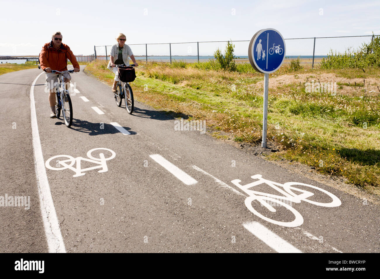 People riding bicycles along Nautholsvik beach, Reykjavik Iceland. Stock Photo