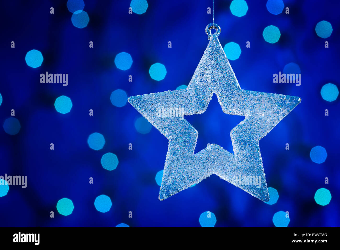 Christmas glass star. Defocused lights background. aRGB. Stock Photo