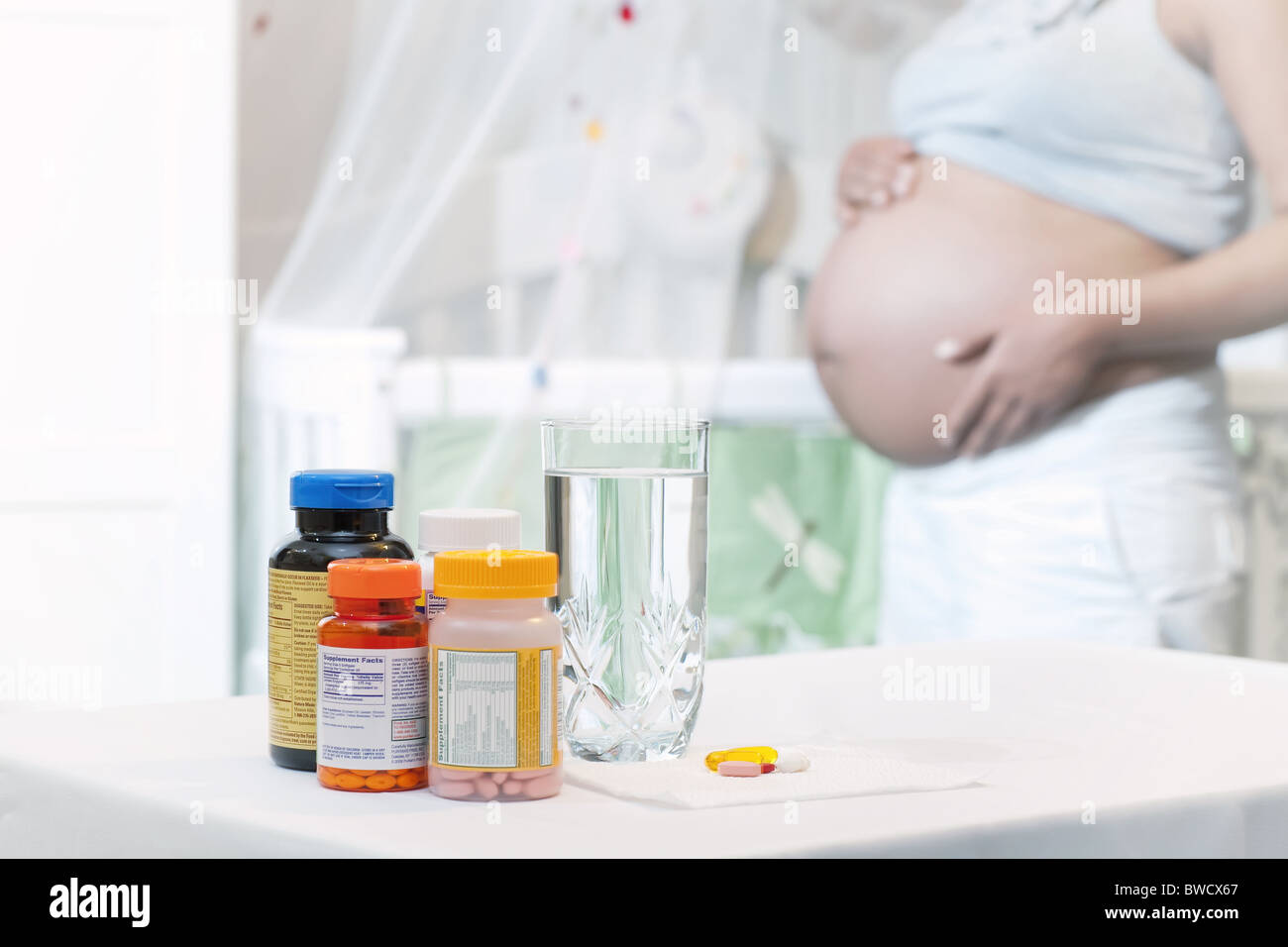 Prenatal vitamins mother holding belly nursery healthy baby Stock Photo