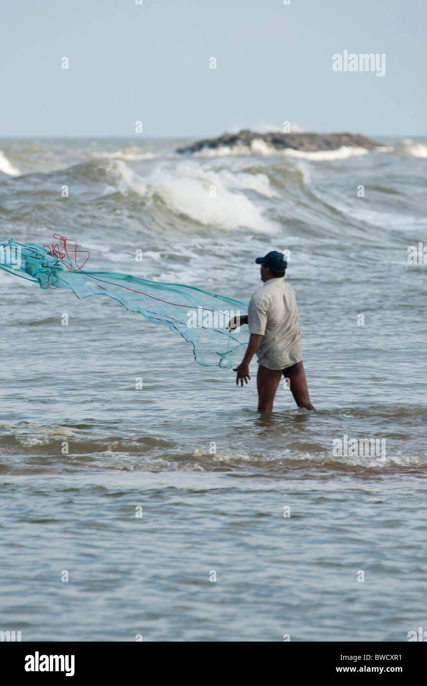 Sri Lankan fisherman casting his net in shallow water Stock Photo