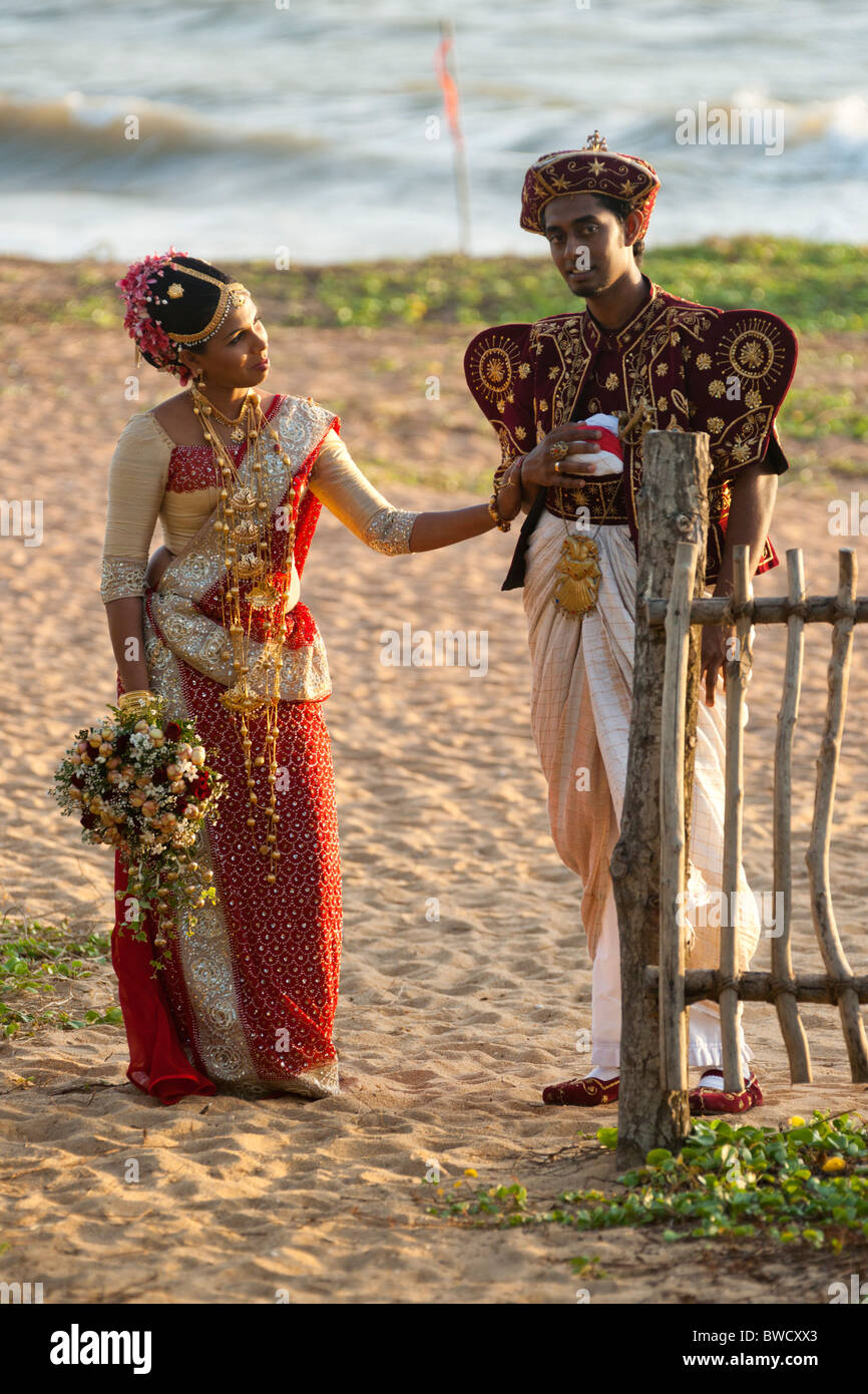 Traditional Sri Lankan bride and groom following their wedding, on a beach, Sri Lanka Stock Photo