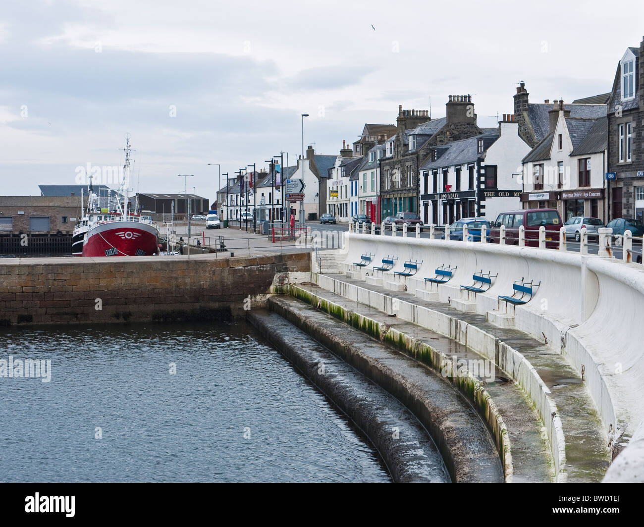 Shore Street harbourfront in the  fishing port of Macduff, sheltered blue benches looking out to sea Aberdeenshire, Scotland, UK Stock Photo