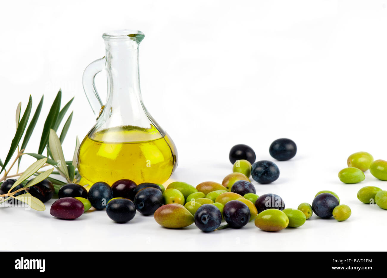 Cold pressed, extra virgin olive oil from Spain with a fresh crop of autumn picked green and black olives. On white. Stock Photo
