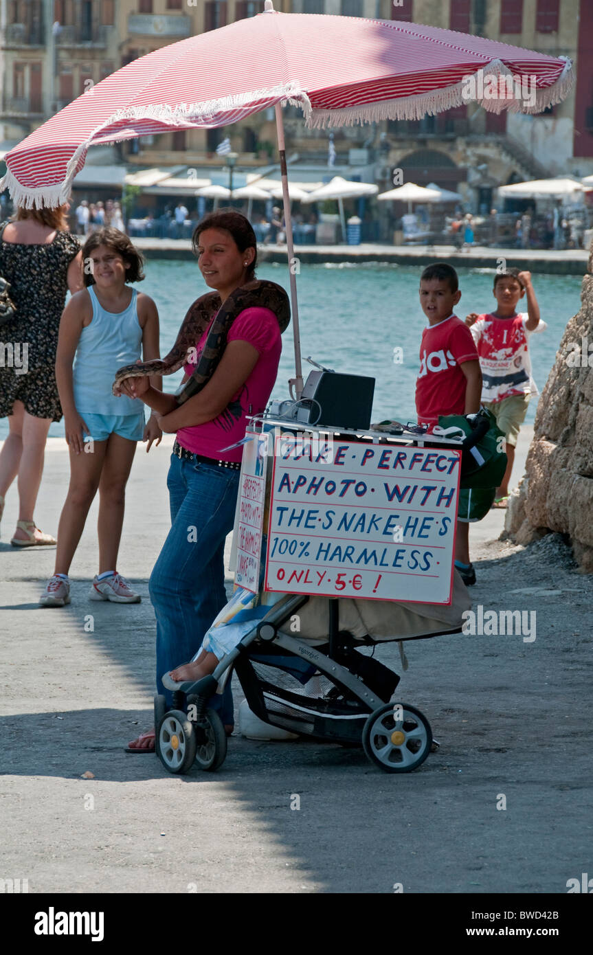 Street vendor using live snake as photographic prop. Chania, Crete, Greece. Stock Photo